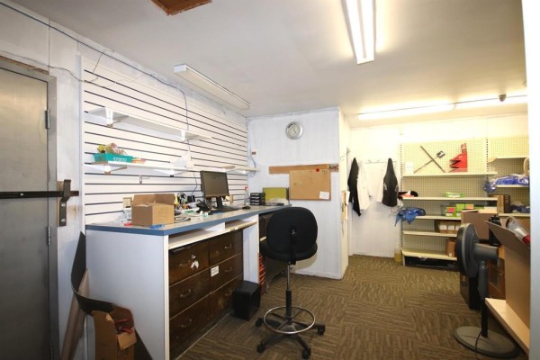 Long aisle with empty shelving units and a dark floor - 66 Main Street S, Carman