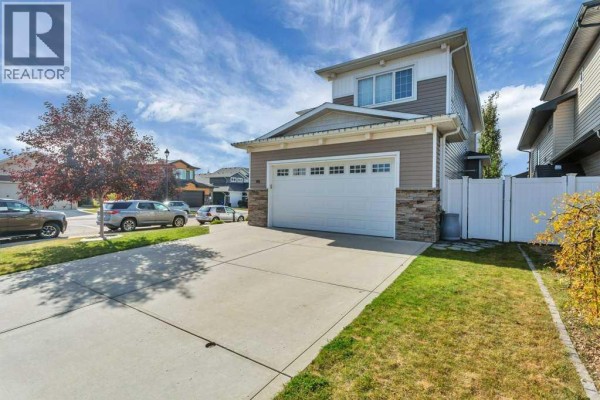 Exterior view of the house from the driveway showing the garage and front yard. - 66 Morris Court, Blackfalds