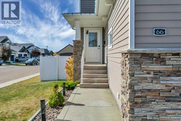 Close-up of the front entrance with a white door, stairs, and stone pillar. - 66 Morris Court, Blackfalds
