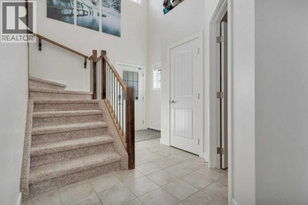 View of the staircase and hallway inside the house with carpeted steps. - 66 Morris Court, Blackfalds