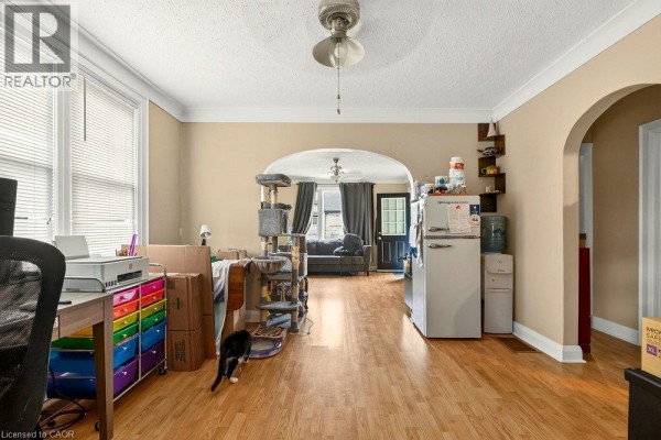Interior view showing a living room, kitchen area with a refrigerator, and a doorway. - 66 Queen Street S Unit# Front Unit, Thorold