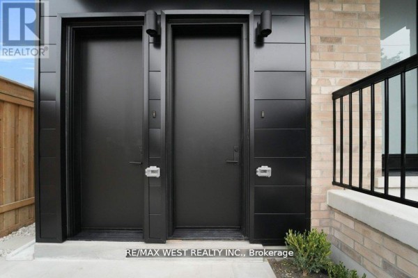 Two black front doors with modern hardware and a small entryway - 661 Winona Drive, Toronto