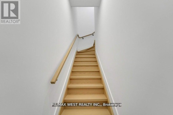 Wooden staircase leading to upper floors with white walls and railing - 661 Winona Drive, Toronto