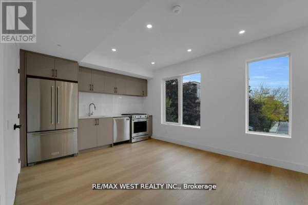 Open-concept kitchen with stainless steel appliances, grey cabinets, and large windows - 661 Winona Drive, Toronto