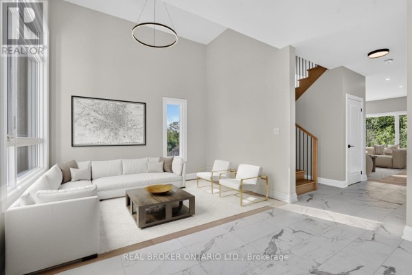 Living room with vaulted ceiling, sectional sofa, and view of staircase and hallway. - 6632 Alexa Common, Niagara Falls