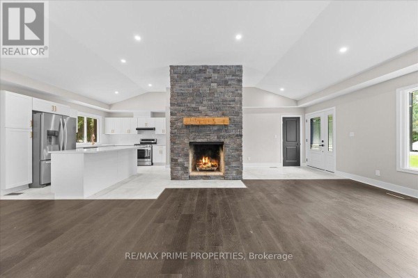 Living and dining area with neutral-colored couches, a dining set, vaulted ceiling, and large windows. - 6636 Marina Drive, Ottawa