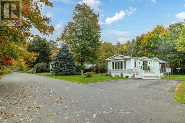 View of the property entrance and manufactured home with autumn trees in the background. - 6636 Vista Patrick Private, Ottawa