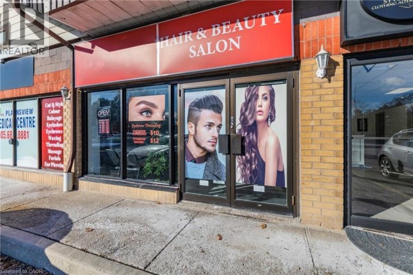 Side view of salon entrance highlighting promotional posters and open sign. - 665 Plains Road E Unit# 6, Burlington