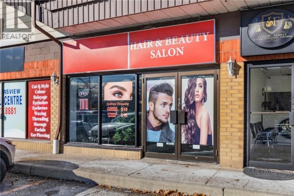 Interior view of salon with seating area, holiday decor, and large windows. - 665 Plains Road E Unit# 6, Burlington