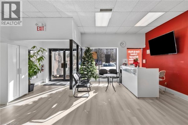 Reception area with service counter, product display, and wall-mounted TV. - 665 Plains Road E Unit# 6, Burlington