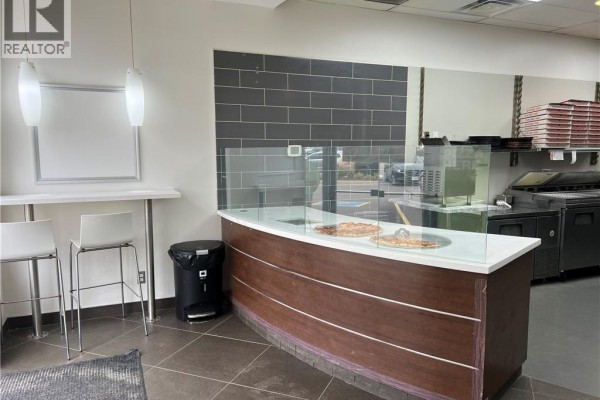 Stainless steel racks with white trays of food items in a walk-in cooler. - 668 W Erb Street Unit# B9, Waterloo