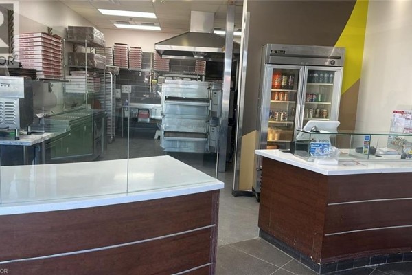 Interior view of pizza restaurant kitchen and customer service area with ovens. - 668 W Erb Street Unit# B9, Waterloo