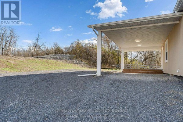 Covered carport area with wooden deck and exterior doors and windows. - 6682 Wheeler Street, Stone Mills