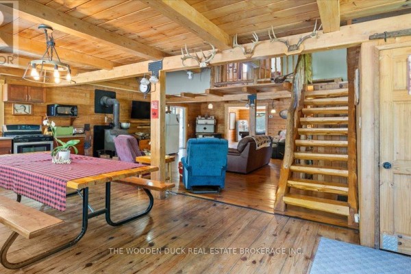Aerial view of the property showing a fire pit, cabin, and surrounding trees. - 6683 Old Hastings Road, Tudor And Cashel
