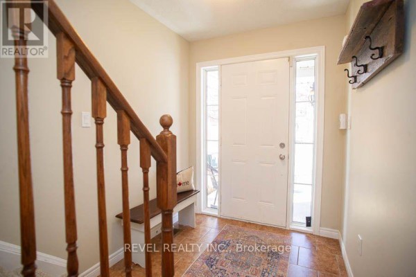 Living area with TV, seating, dining table, and kitchen island, featuring hardwood flooring - 67 - 20 Mcconkey Crescent, Brantford