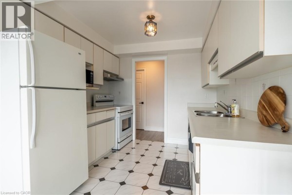 Kitchen with white appliances, geometric tiles, and doorway - 67 Caroline Street S Unit# 13a Hamilton