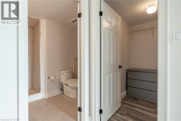 Shower, toilet, and closet with dresser in a modern bathroom - 67 Caroline Street S Unit# 13a Hamilton