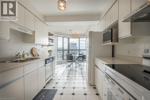 Kitchen with white cabinets, dining table, and bay windows - 67 Caroline Street S Unit# 13a Hamilton