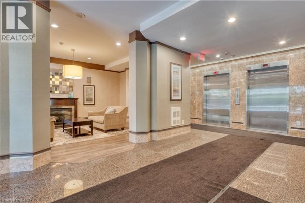 Building lobby with seating area, fireplace, and two elevators - 67 Caroline Street S Unit# 13a Hamilton