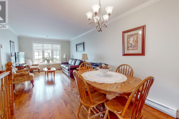 Dining area with a wooden table and chairs, adjacent to the living room and hallway. - 67 Gisborne Place, St  John S