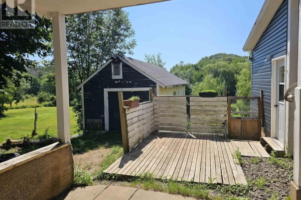 Overhead view of a backyard with a fire pit, garden beds, and trees. - 67 Lawrencetown Lane, Lawrencetown