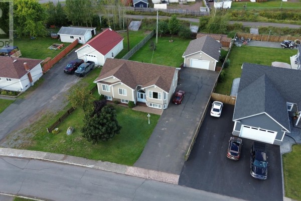 Aerial view showing the house, garage, and neighboring properties on a paved street. - 67 Marshalls Drive, Bishop S Falls
