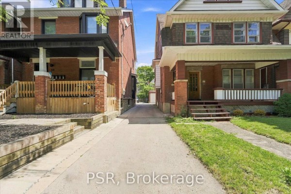A narrow driveway runs between two brick houses, leading towards the back of the properties. - 67 Oakwood Avenue, Toronto
