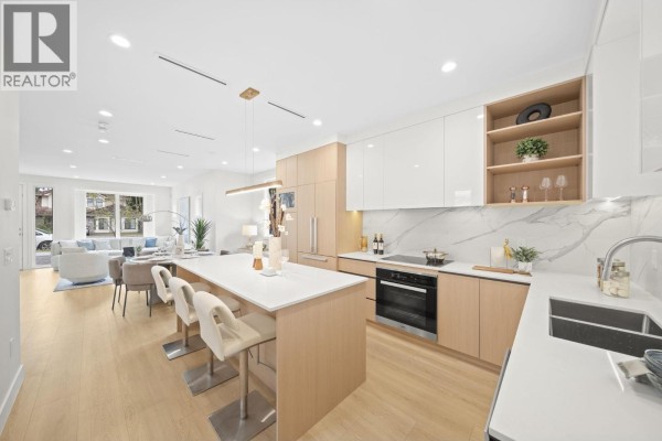Open concept kitchen and living area with a large island and dining table. - 6700 Francis Road, Richmond