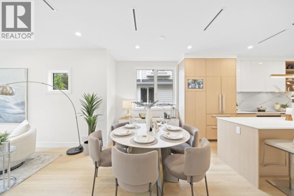 Dining area with a round table, velvet chairs, and view of the kitchen. - 6700 Francis Road, Richmond