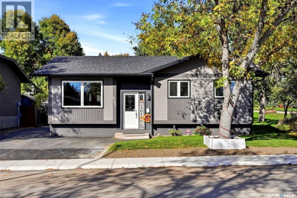 Front exterior of a grey bungalow with white trim and a double front door. - 6702 Whelan Drive, Regina