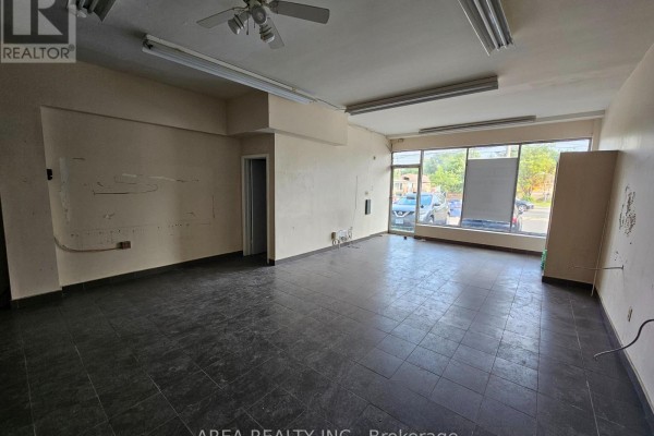 Commercial space with dark tile floor, white walls, and a view into another room. - 672 Sheppard Avenue W, Toronto