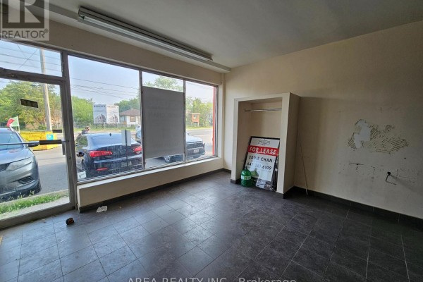 Interior view of a commercial space with dark tiled floor and bare walls. - 672 Sheppard Avenue W, Toronto