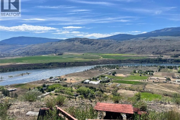 View overlooking the Thompson River, agricultural fields, and scattered homes surrounded by rolling, dry hills. - 6736 Pinecrest Drive, Kamloops