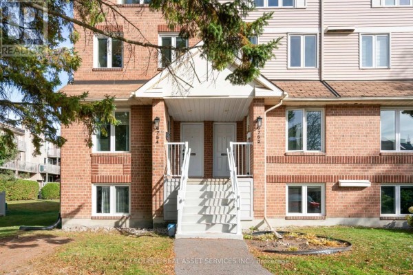 Close-up exterior view of apartment building entrances with white doors and stairs. - 6754b Jeanne-d'arc Boulevard N, Ottawa