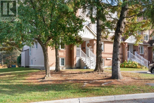 Exterior view of apartment building entrances framed by trees and greenery. - 6754b Jeanne-d'arc Boulevard N, Ottawa