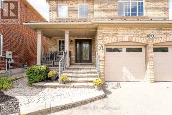 Close-up of the front entrance porch with a covered roof, columns, and stone steps. - 6782 Kazoo Court, Mississauga