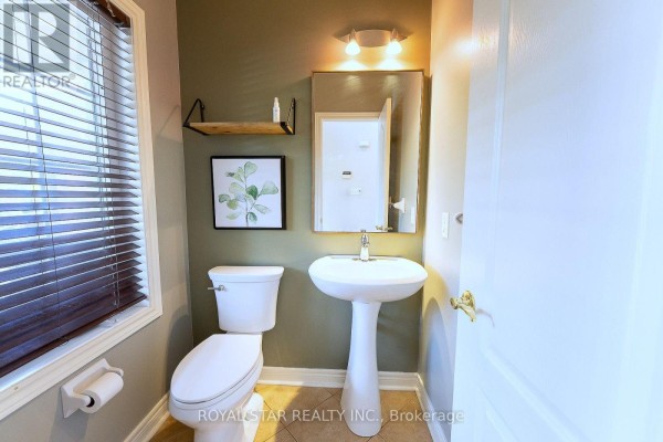 Powder room with a pedestal sink, toilet, and a window with horizontal blinds. - 6782 Kazoo Court, Mississauga