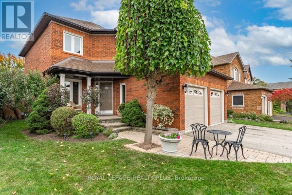 Exterior view of a red brick house with a covered porch and double garage doors. - 6795 Gracefield Drive, Mississauga