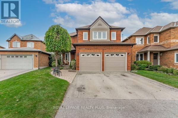 Frontal view of a large red brick house with two garage doors and mature trees. - 6795 Gracefield Drive, Mississauga