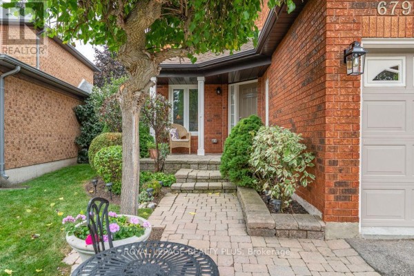 Stone steps lead to the covered porch of a red brick house with a paved walkway. - 6795 Gracefield Drive, Mississauga