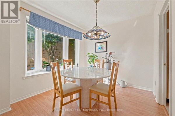 Dining room featuring a round marble table with wooden chairs and a bay window. - 68 - 4635 Regents Terrace, Mississauga