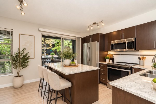 Kitchen with dark wood cabinets, granite island, stainless steel appliances. - 68 19250 65 Avenue, Surrey