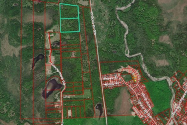Aerial view with property lines and two turquoise outlines highlighting a cleared section of land near a wooded area. - 68-76 Hillier Avenue, Stephenville