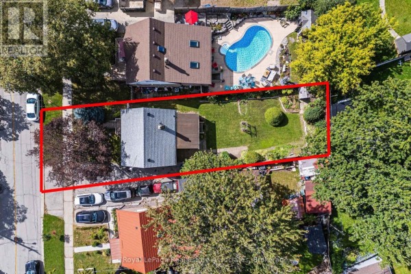 Top-down aerial view of a backyard featuring a swimming pool, green lawn, and trees. - 68 Allenby Avenue, Toronto
