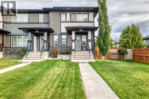 Front exterior view of the townhouse complex at 68 Belgian Street, Cochrane, with green lawn and wooden fence. - 68 Belgian Street, Cochrane
