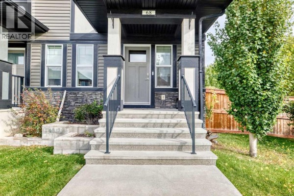 Close-up of the townhouse entrance at 68 Belgian Street, featuring grey double doors, stone accents, and covered porch. - 68 Belgian Street, Cochrane