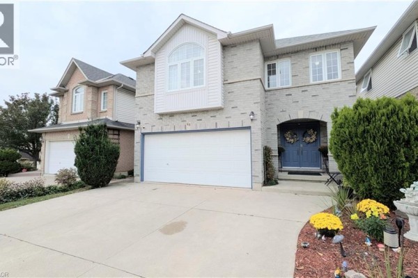 Front exterior of a two-story house with light grey brick and a double door entrance. - 68 Benjamin Drive, Hamilton