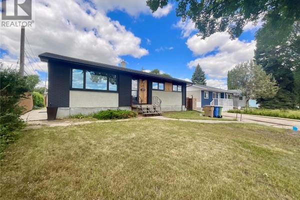 Front three-quarter view of the bungalow exterior on a sunny day with scattered clouds. - 68 Cameron Crescent, Regina