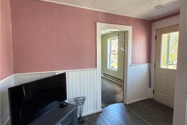 Living room corner with television, trash can, and doorway to another room. - 68 Cunard, Miramichi