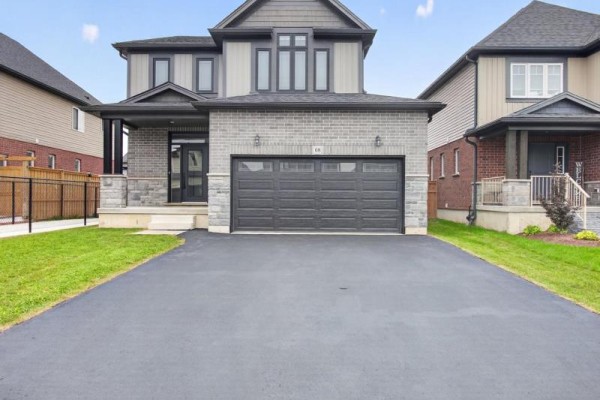 Front view of the house showing the garage door, front entrance, and lawn. - 68 Davidson Drive W, Stratford